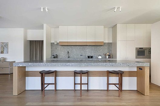 Exploring the Plant Street kitchen, your eyes are immediately drawn to the long island benchtop that spans most of the space. The materials used throughout the room create a cohesive motif: natural oak veneer forming a strip line below the island benchtop, a white 2-pac finish, and terrazzo slabs with colored rocks as the island’s tabletop, adding the final touch. All three elements come together beautifully with the island.