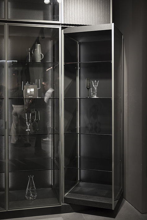 Design in a class of its own: Eggersmann showed a rotating glass display element in a tall unit with integrated lighting, realised with the innovative FurnSpin turning swivelling fitting. Photo: Hettich 