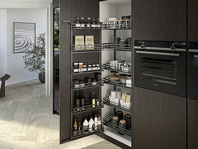The “Iseo” swivelling pull-out from Hettich guarantees optimum organisation and ergonomic access to all contents, even at the back of the tall unit. The flat wire railing in elegant anthracite (DesignLine 400) underscores the clean lines. Photo: Hettich