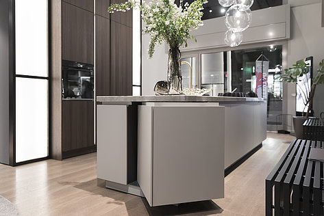 The new S2 from SieMatic combines matt surface finish with real wood and stone. SecretSpace – the rotating shelf element in the kitchen island, made possible with FurnSpin from Hettich – features a combination of these materials. Photo: Hettich